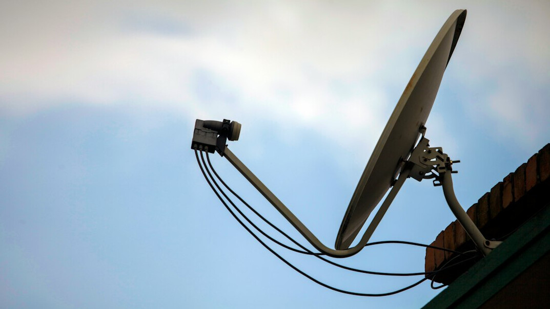 Satellite uplink dish and outside broadcast van transmitting a live television signal