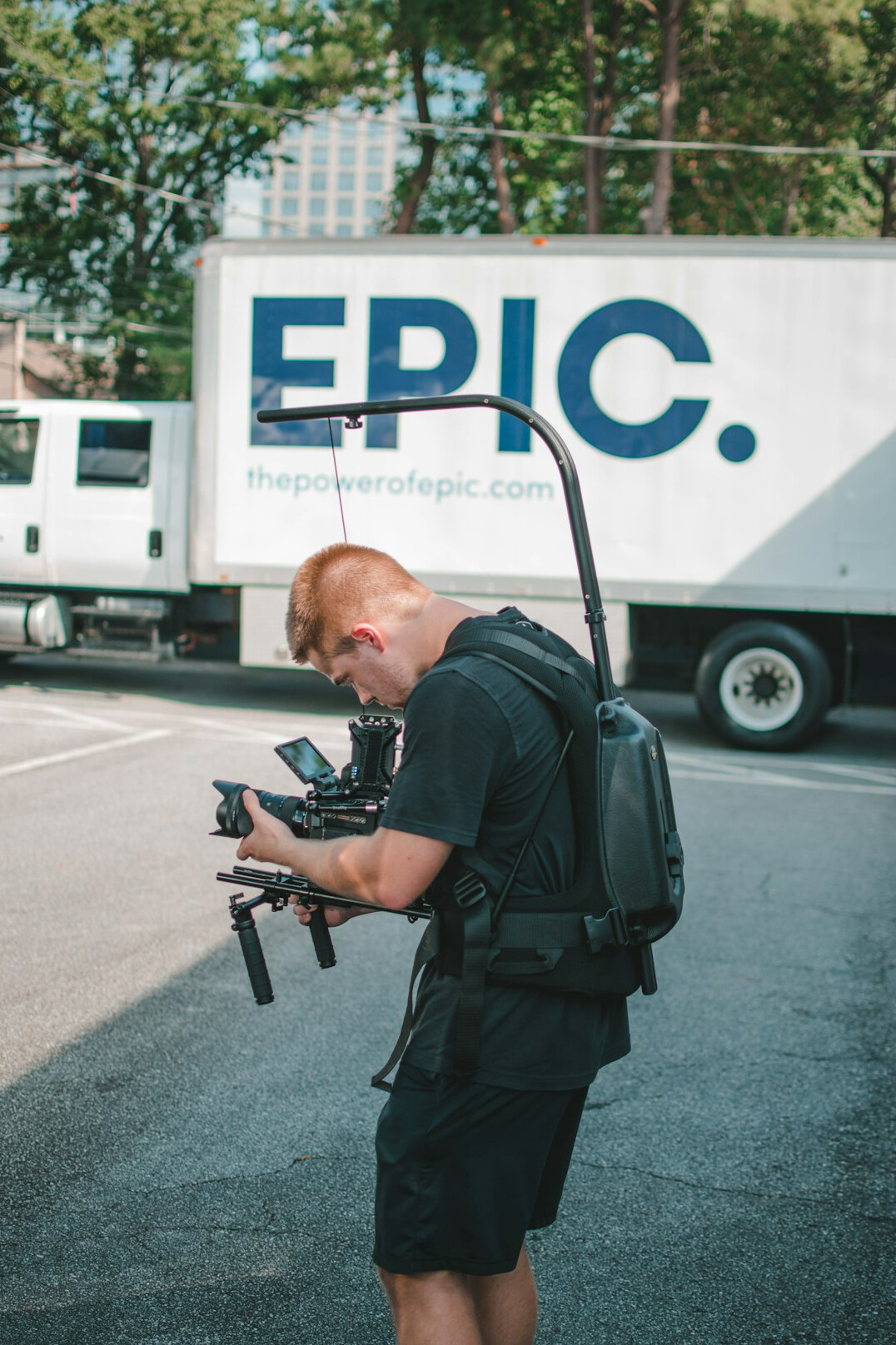 ENG camera operator holding a shoulder-mounted broadcast camera on location