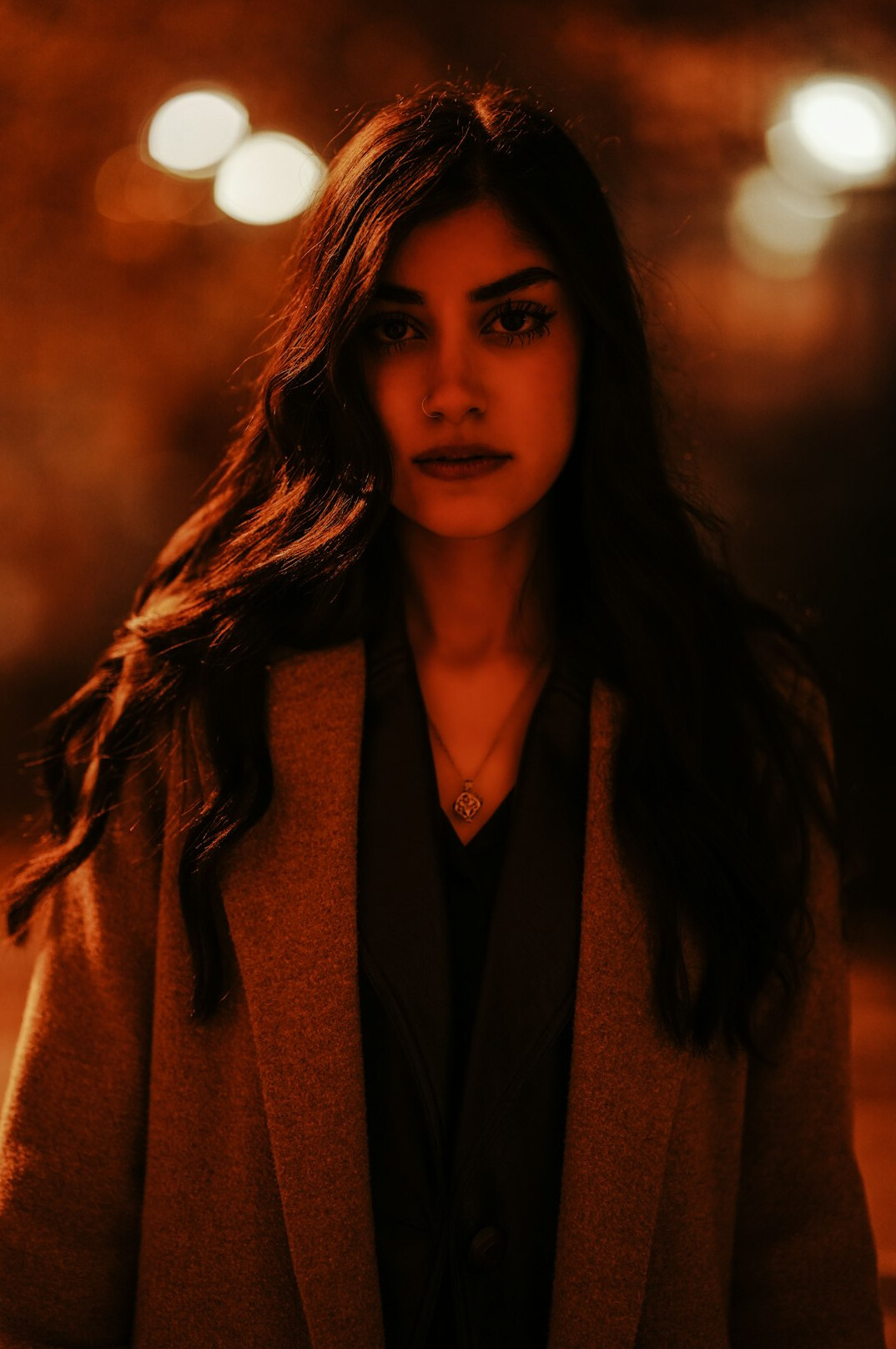 Studio portrait of a British woman in her thirties with shoulder-length hair wearing a blazer